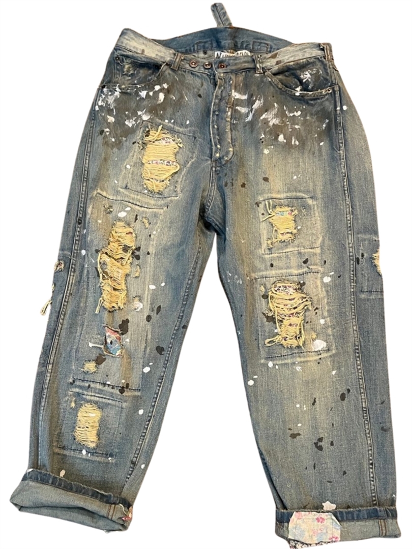 Jeans with paint, distressing, and fabric patch detail